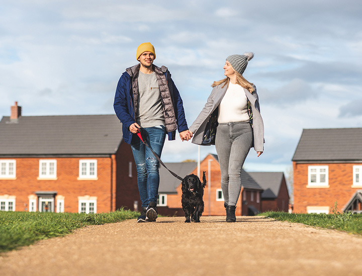 A young couple walking along a footpath with their dog
